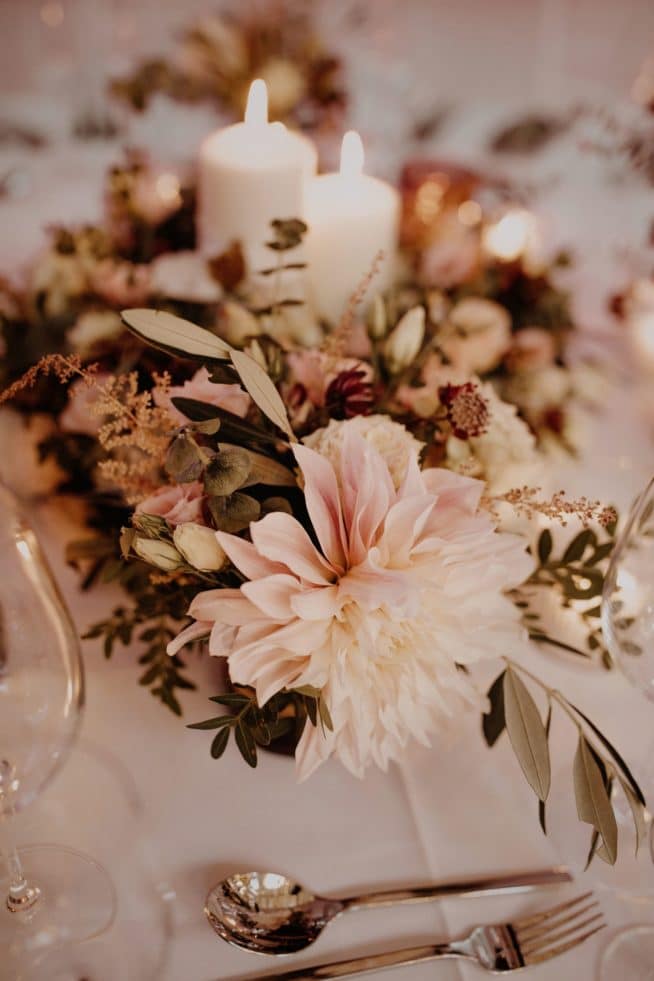 Festlich gedeckter Hochzeitstisch im Saal mit Blumen