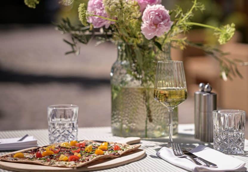 Unser begrünter Hofgarten mit Getränken, einem Flammkuchen und Blumen
