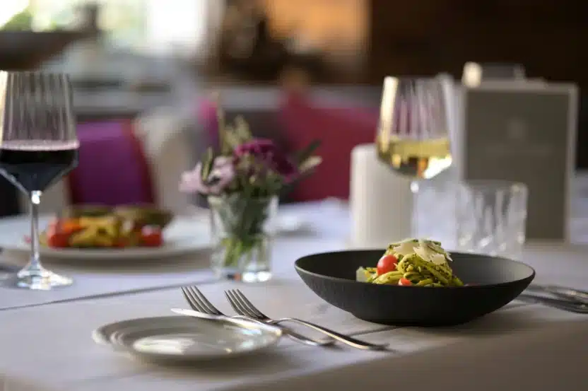 Essen auf dem Tisch in der Kronenstube im Landhotel 3Kronen mit Weingläsern