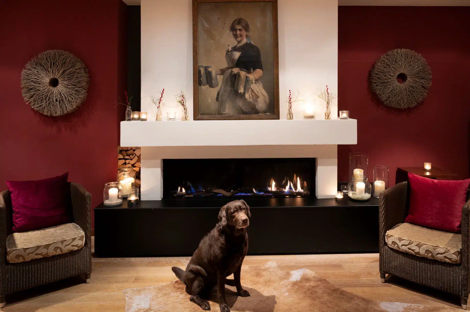Hund sitzt vor dem Kamin