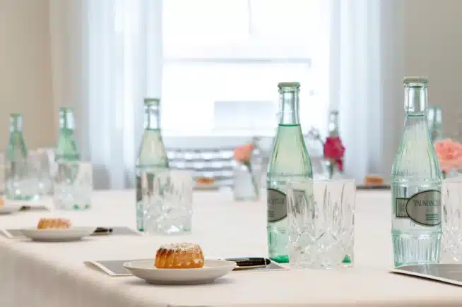 Tagungstisch mit kleinen Gugelhupfen und Wasser auf dem Tisch