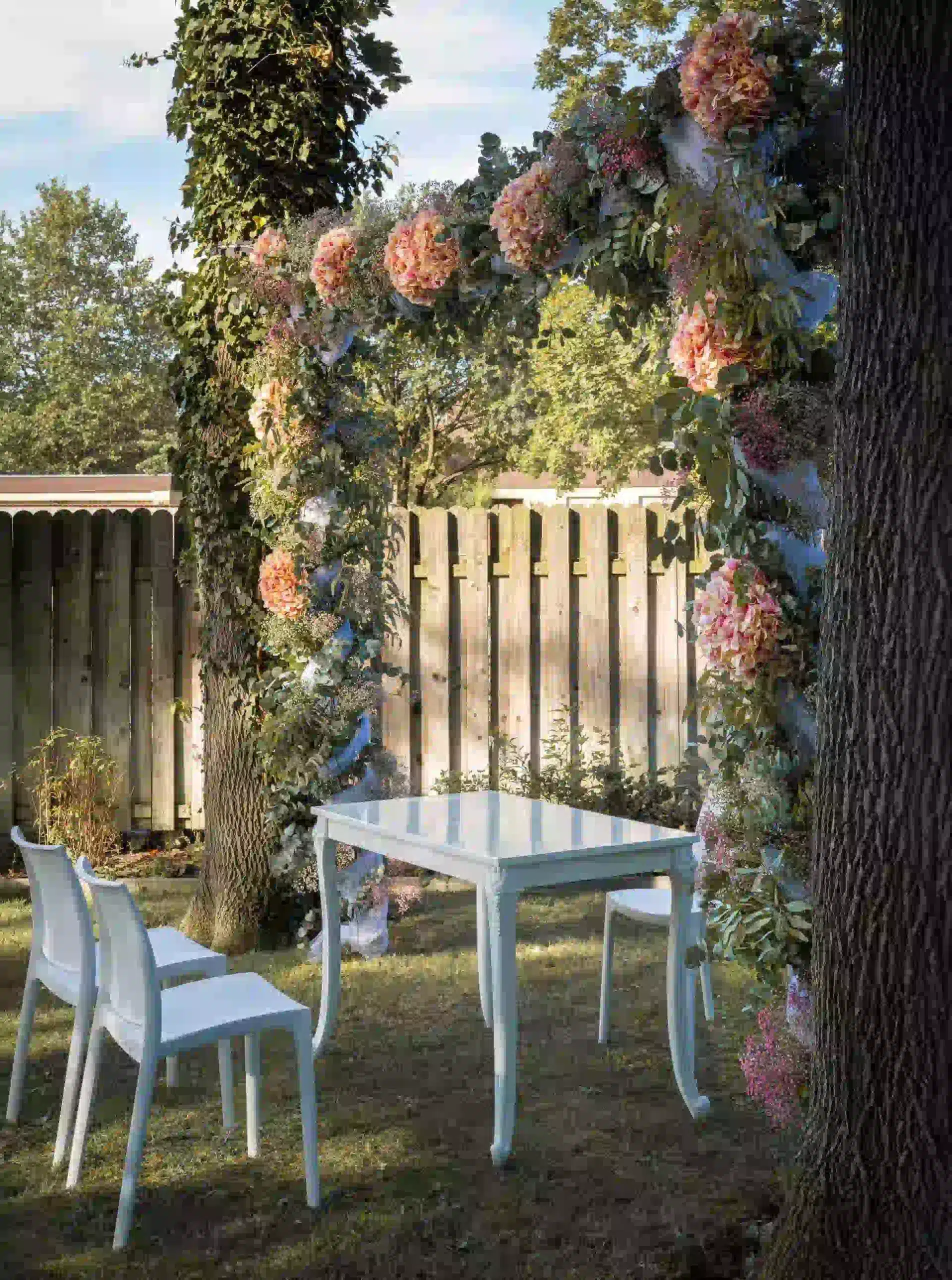 Traubogen mit rosafarbenen Blumen und Trautisch