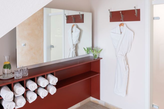 Blick auf einen Bademantel und Handtücher im Wellnessbereich