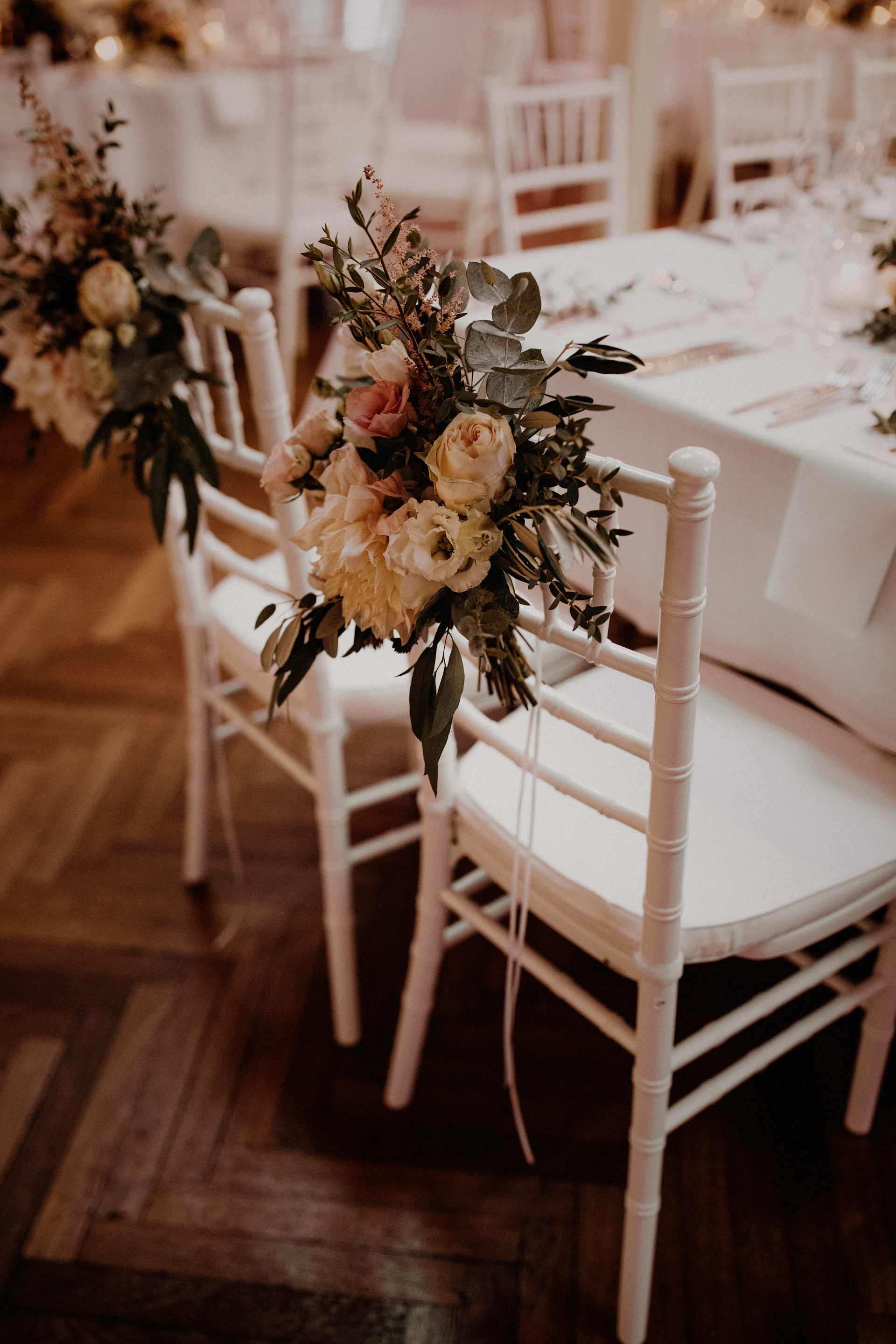 Stühle festlich geschmückt mit Hochzeitsblumen